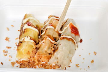 Close up view of 3 Japanese gyoza dumplings served in a white street food styrofoam container