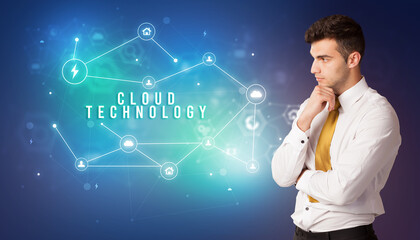 Businessman in front of cloud service icons with CLOUD TECHNOLOGY inscription, modern technology concept