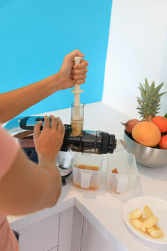 Young woman using a juice extractor