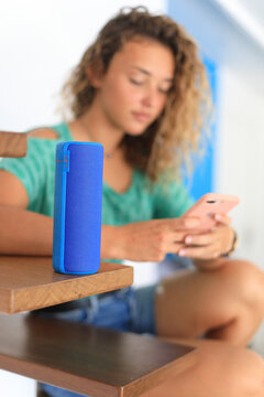 Young woman at home using a connected speaker
