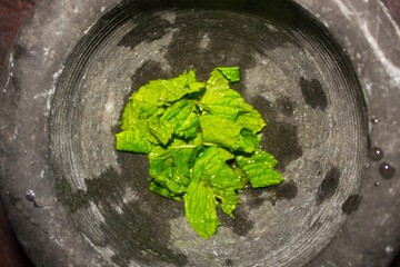 evocative image of chopped mint leaves and placed in a kitchen mortar ready for mojito
