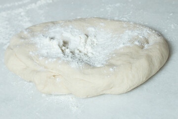 Homemade fluffy bread dough with traces of flour from the first fermentation on a marble table.
Steps to make bread at home.
