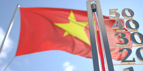Thermometer shows high air temperature against blurred flag of Vietnam. Hot weather forecast related 3D rendering