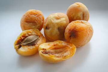 A group of old and spoiled apricots on a white background. Non-isolated photography