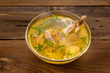 Bouillon quail egg in a transparent round plate on a wooden background