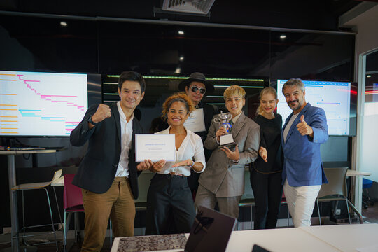 diverse people celebrate teamwork to win trophy award and certificate