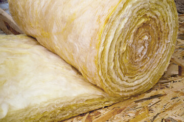 roll of mineral wool lying on the wooden floor