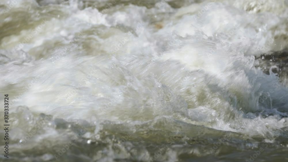 Wall mural Closeup detail, water flowing in river on sunny day forming white waves