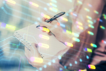 Multi exposure of woman's writing hand on background with data technology hud. Concept of innovation.
