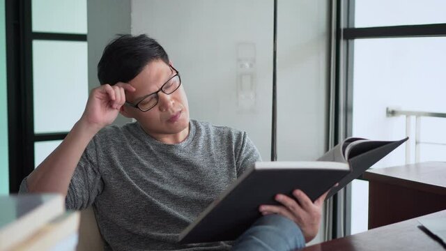 Serious asian young man Read a book Distraction Until having to stop reading