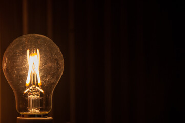 Incandescent lamp On black background. Electricity concept. Light and dark concept