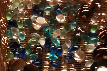 Colorful glass and seashells in wicked basket