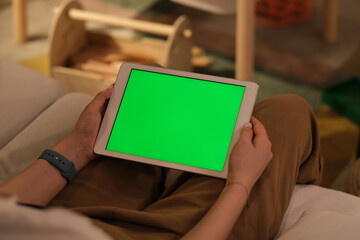 over shoulder view of people holding green screen tablet at home