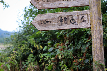 Wooden signpost for the toilets