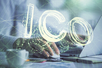 Blockchain theme hologram with man working on computer on background. Concept of crypto chain. Double exposure.