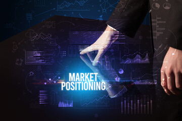 Businessman touching huge screen with MARKET POSITIONING inscription, cyber business concept