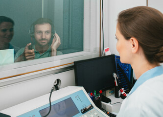Mixed race man getting a hearing test at a doctor's office, audiometer hearing test in a special...