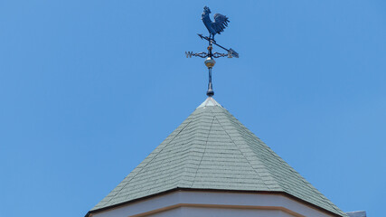 青空を背景に屋根の上の風見鶏