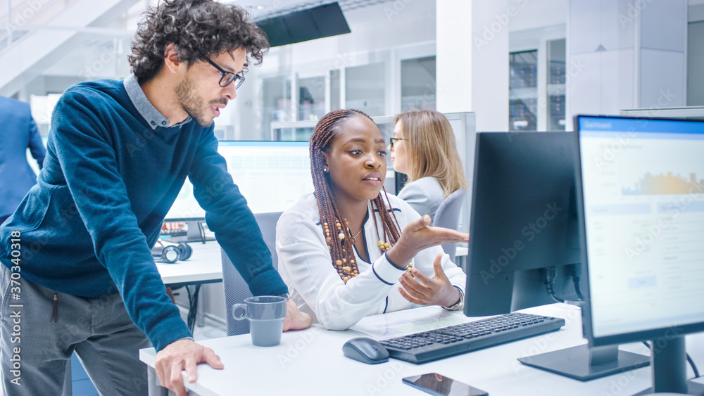 Poster in the busy corporate office: manager talks to businesswoman who works on desktop computer. business