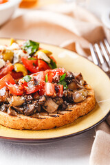 Delicious bruschettas with mushrooms, blue cheese, olives and tomatoes