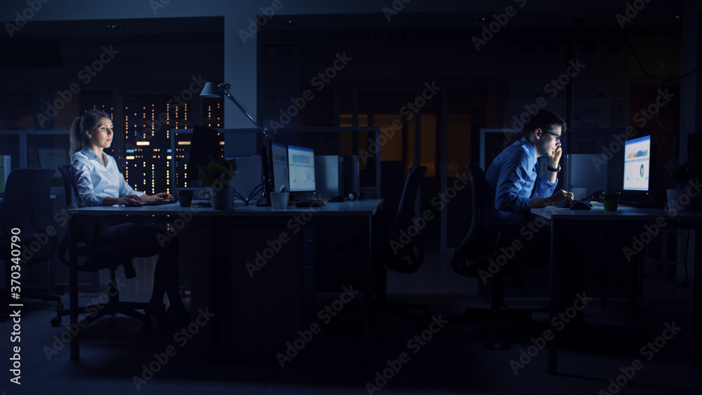 Poster Working Late at Night in the Office: Businesspeople Use Desktop Computer, Analyzing, Using Documents, Solving Problems, Finishing Important Project. Side View
