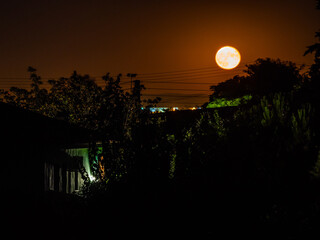 Lights of a house with the moon in the background © Remei