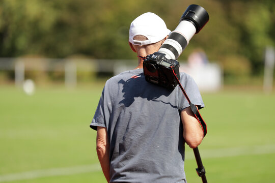 sportfotograf mit kamera auf einem fu&szlig;ballplatz