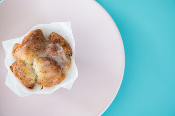 Appetizing cupcake on a pink dish on turquoise background