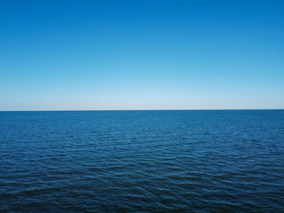 Obraz premium Merger of sky and sea in the horizon, blue water and cloudless sky.