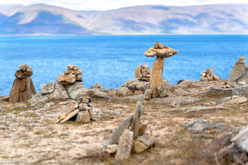 Balanced stone pyramids on lake shore. Zen rock, concept of balance and harmony