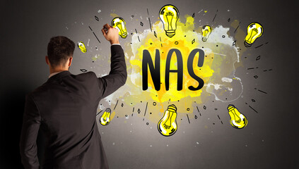 businessman drawing colorful light bulb with NAS abbreviation, new technology idea concept