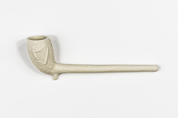 Traditional classic style white clay smokers pipe shot sideways on in a white studio.