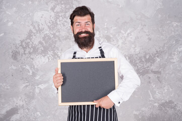 Man good looking hipster cafe barista with blackboard copy space, business contacts concept