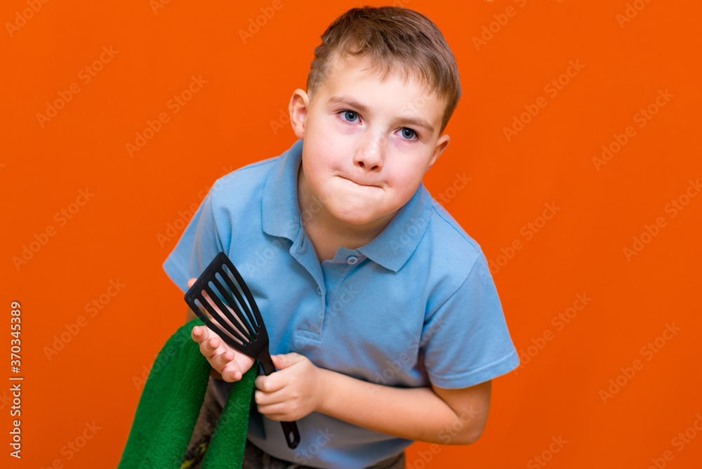 Wall mural portrait of a caucasian boy. the boy holds a paper towel, the other hand used to towel. housewives c