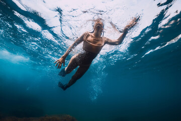 Sporty woman with fins swim in sea. Swimming in ocean