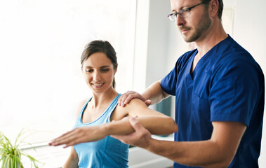 Male Physical Therapist Stretching a Female Patient Slowly.