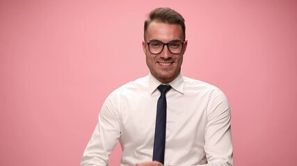 sexy young businessman in white shirt wearing glasses, moving, crossing arms and smiling on pink background