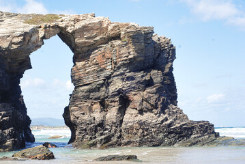 swell between the big rocks in the blue sea