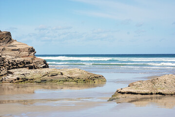 swell between the big rocks in the blue sea