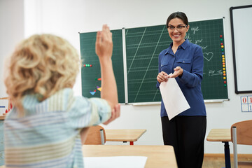 Smiling female teacher and pupil in class room