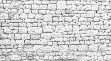 White texture of an old wall made of a multitude of small exposed stones - old vintage texture design - large image in high resolution