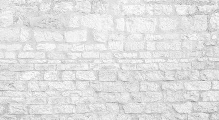 White texture of an old wall made of a multitude of small hewn stones - old vintage texture design - large image in high resolution