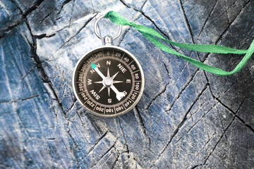 round compass on blue wooden background as symbol of tourism with compass, travel with compass and outdoor activities with compass
