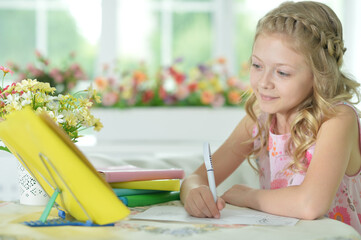 Little cute girl doing homework at home