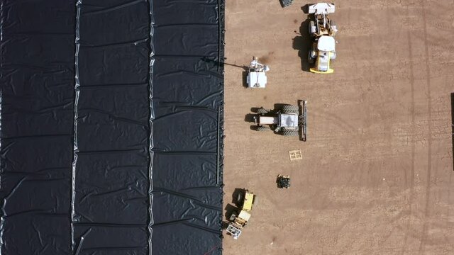 Water reservoir construction site with newly installed plastic lining sheets, Aerial view.