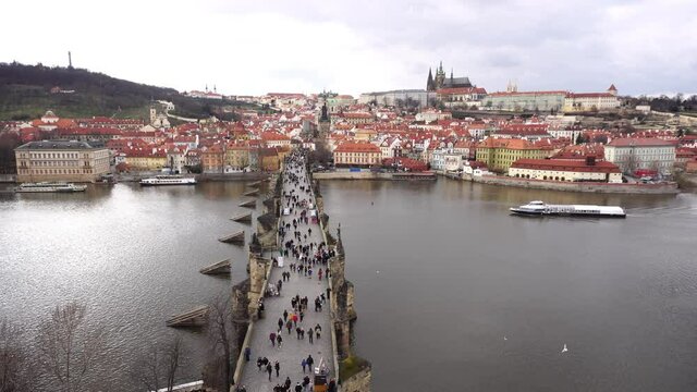 Charles Bridge with people on it from above with boat
