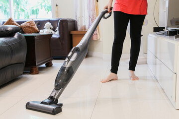 Fototapeta na wymiar Women use the vacuum to clear the floor