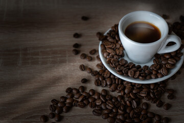 On the table is one Cup of coffee on a saucer with scattered coffee beans.