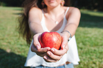 red apple in the hands of a caucasian young woman