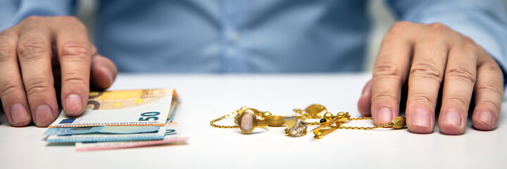 Buying gold jewelry, euro banknotes and hand of a businessman, panorama